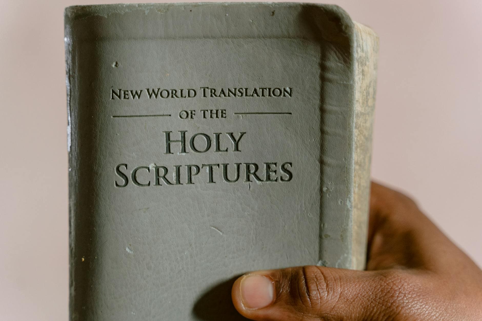 Close-up of a hand holding the New World Translation of the Holy Scriptures.
