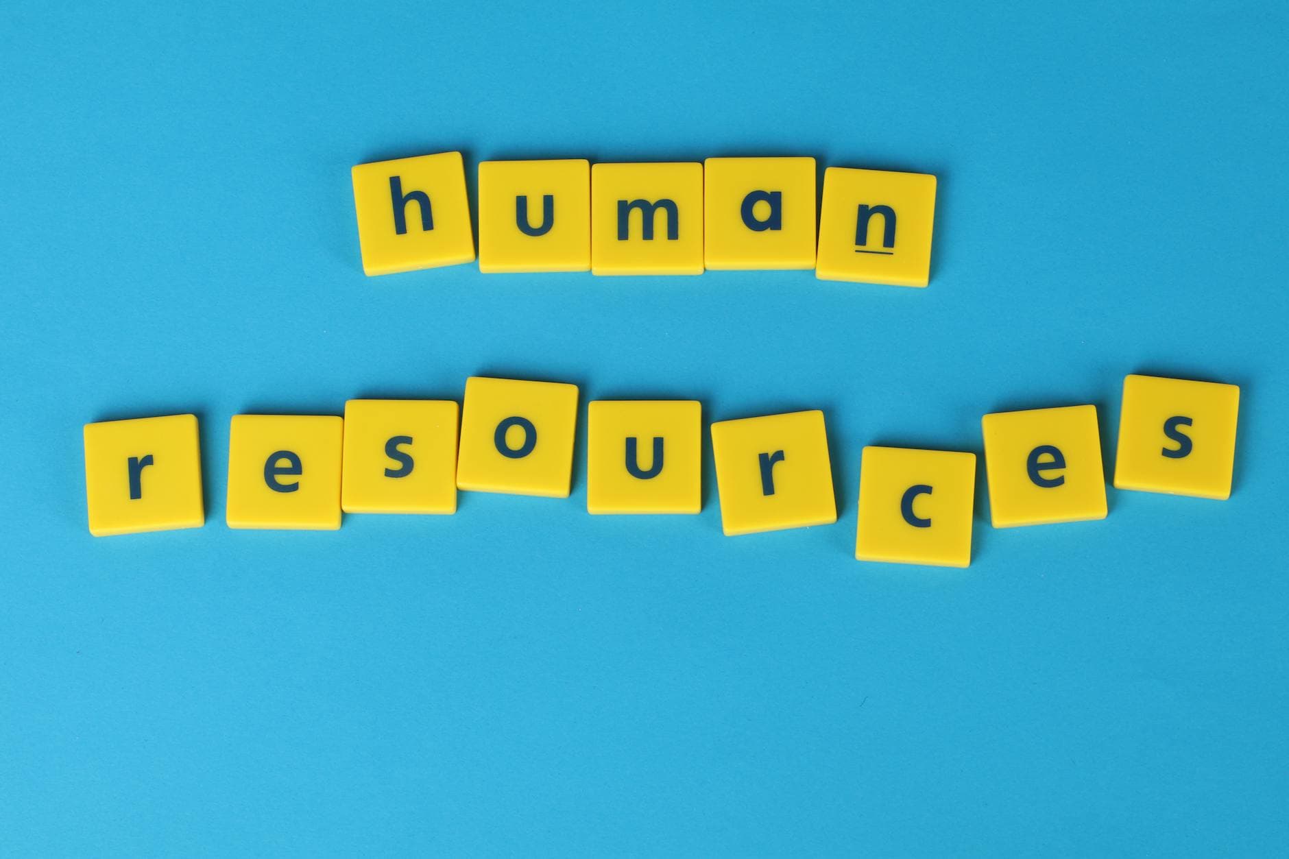 Yellow tiles spelling 'human resources' on a blue background, ideal for HR or business concepts.