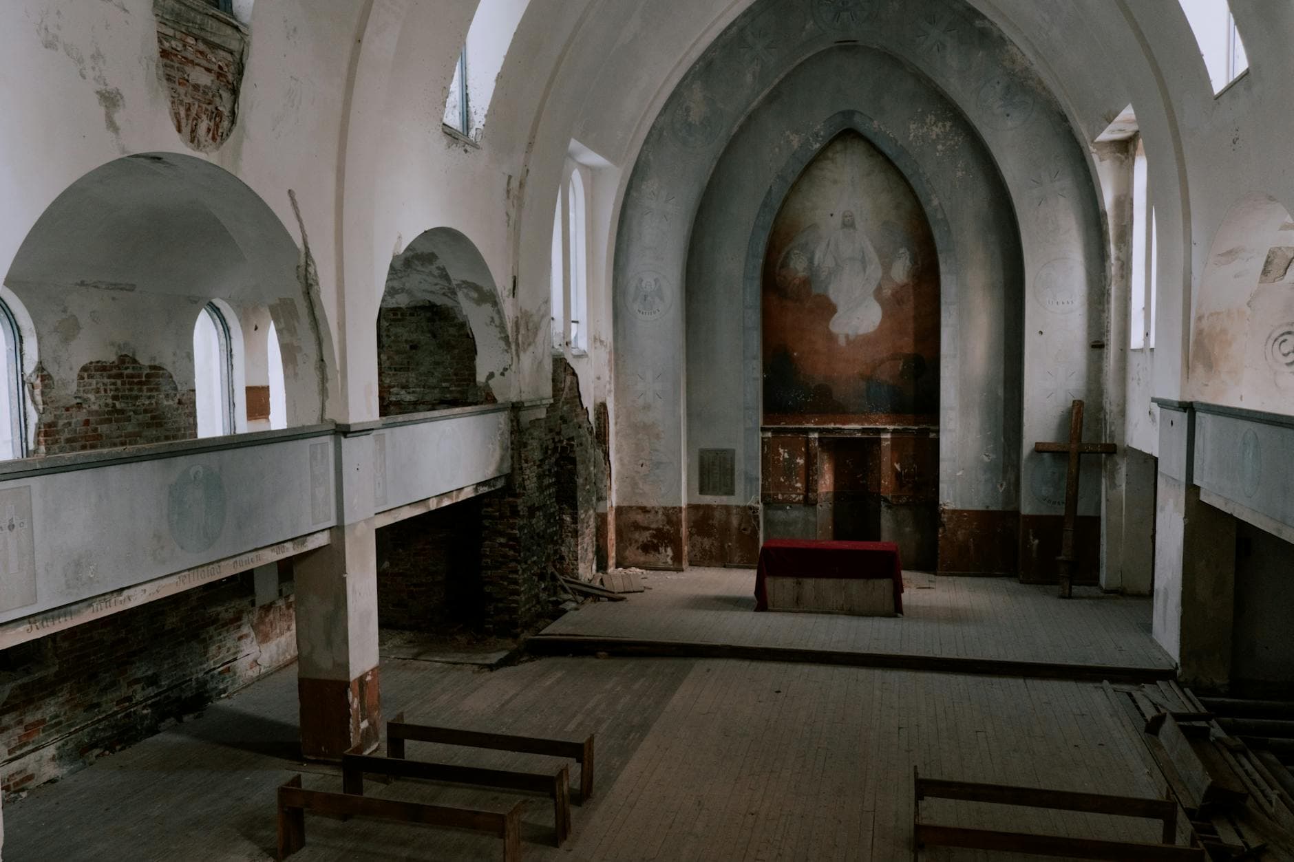 Exploring an abandoned church interior showcasing weathered architecture and altar.