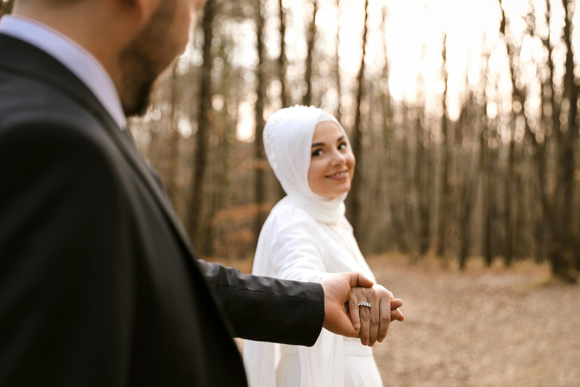 A captivating outdoor wedding portrait of a happy couple holding hands, radiating romance in nature.