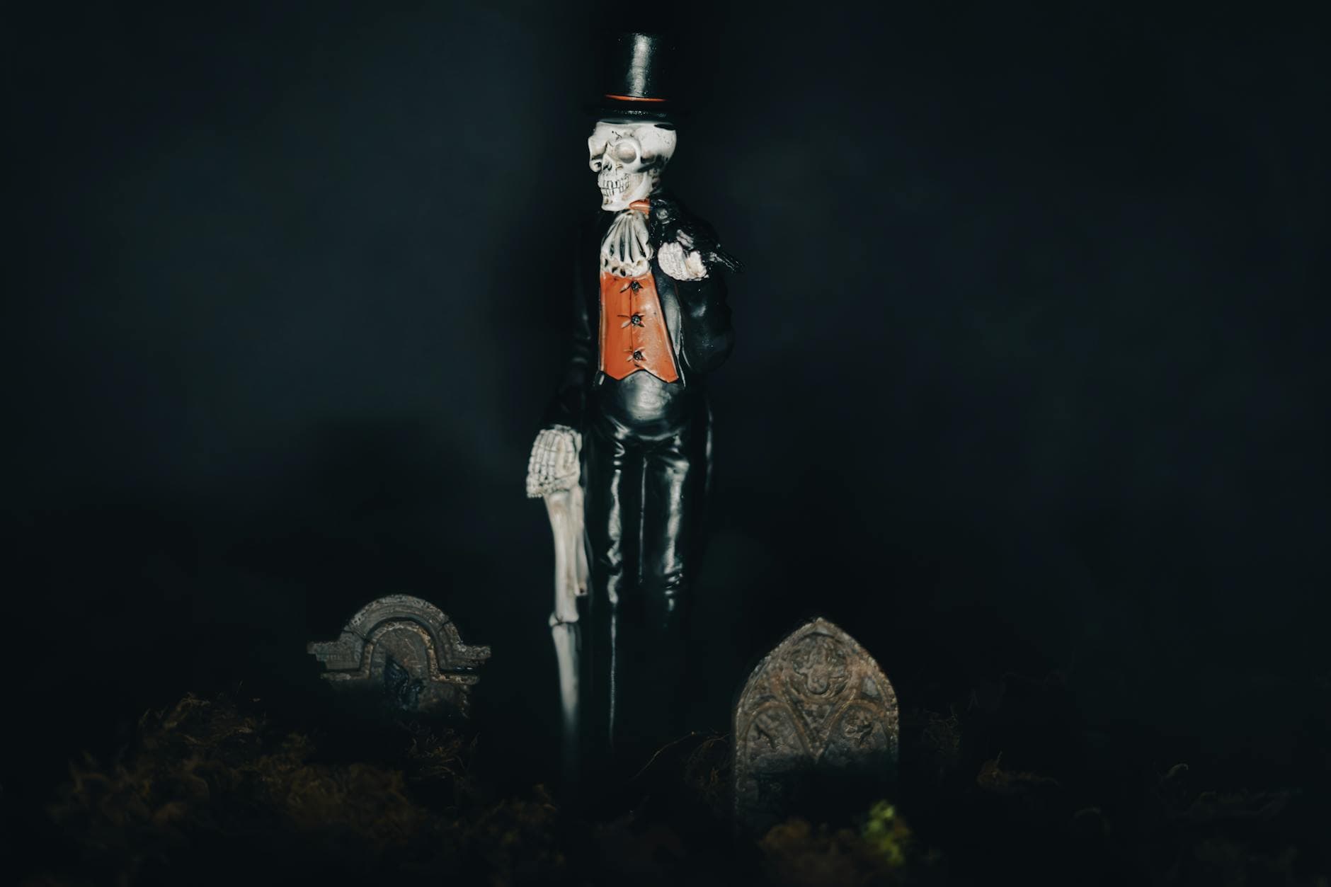 A skeleton figure dressed in formal attire stands in a graveyard, creating a spooky Halloween atmosphere.