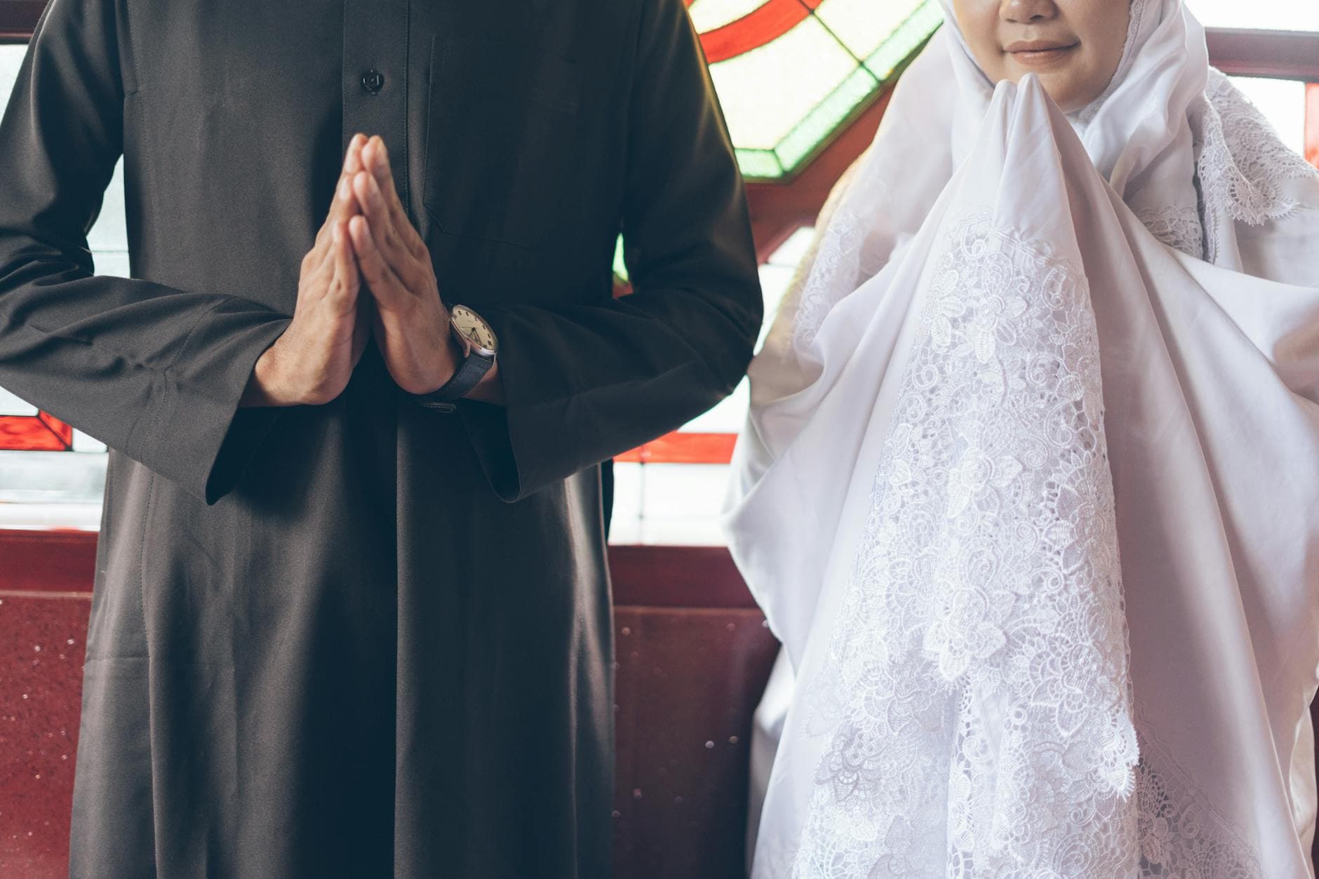 A bride and groom in traditional attire participate in a solemn wedding ceremony.